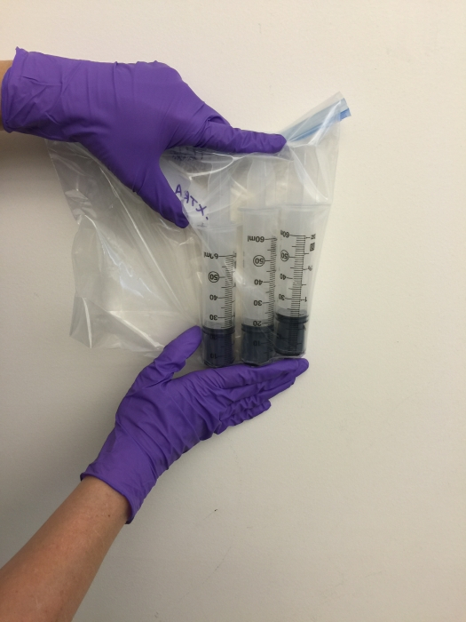 Sediment corers, in the hands of Laurie Van De Werfhorst, for water quality research.